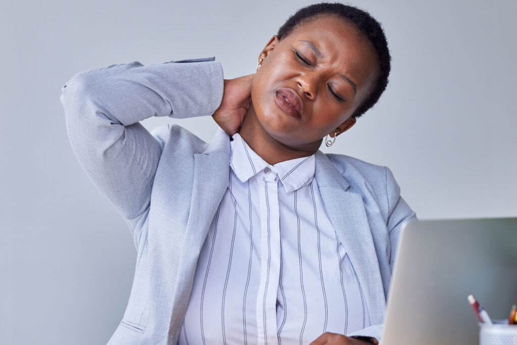 A woman with a stiff neck due to an incorrect ergonomic setup